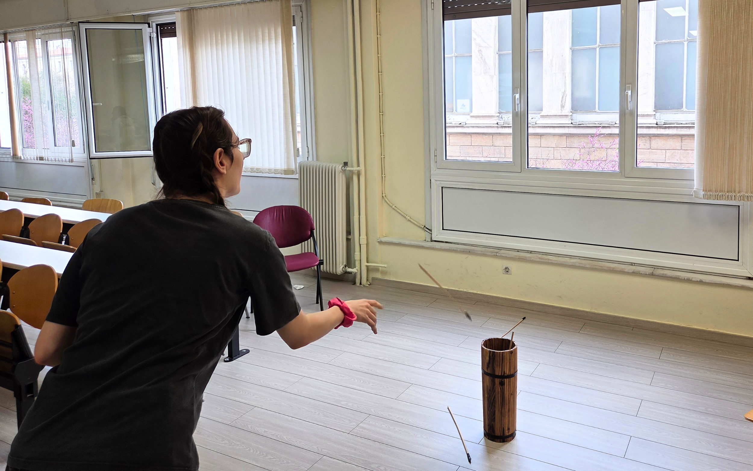 A participant plays the traditional Korean game Tuho during the “Korean Culture Day - Korean Food & Dining Culture” event at the Foreign Language Center in Athens, on April 3 (by Koreaculture.gr)