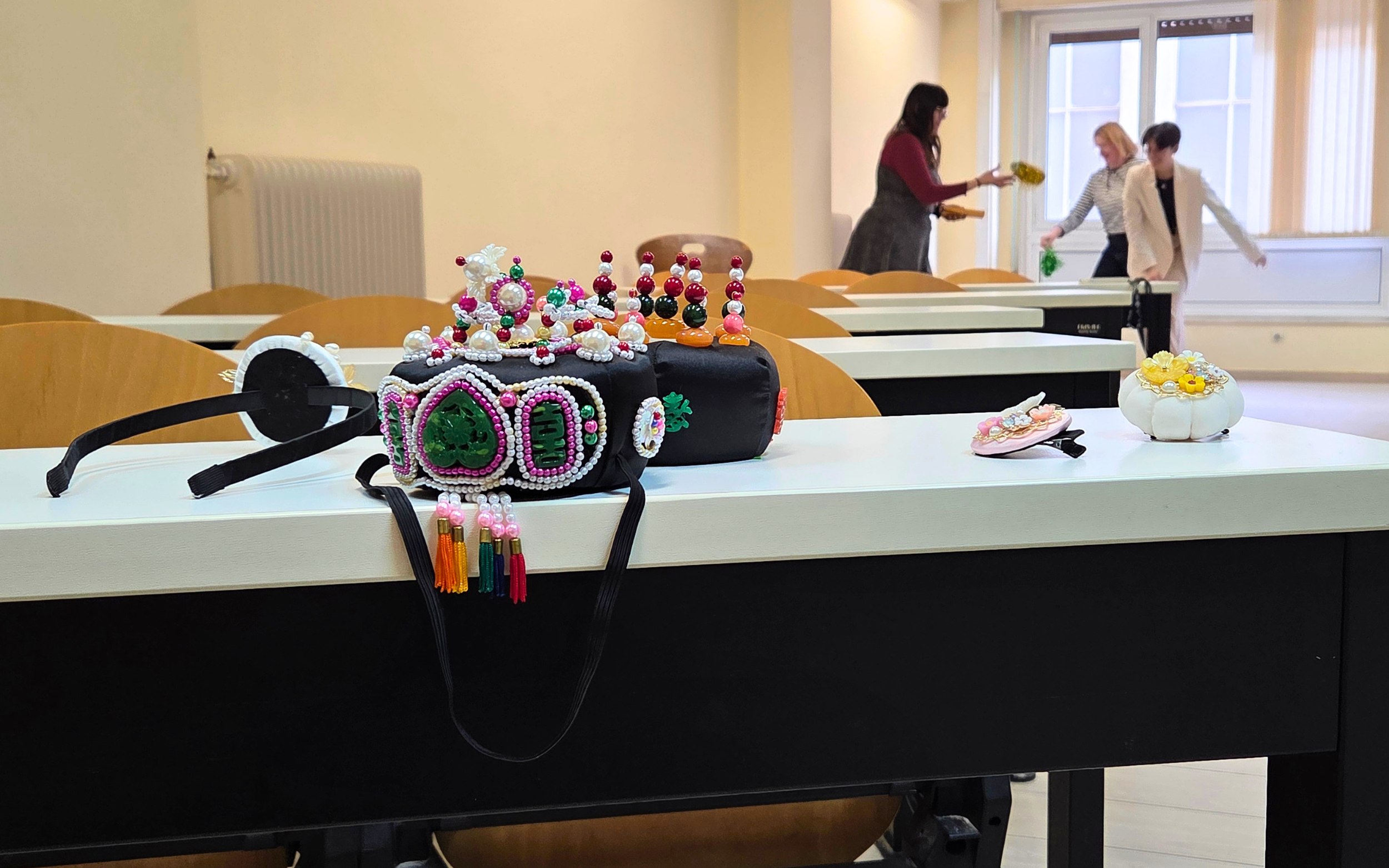 Traditional Korean jewelry in the foreground as participants play jegichagi in the background during the “Korean Culture Day - Korean Food & Dining Culture” event at the Foreign Language Center in Athens, on April 3 (by Koreaculture.gr)